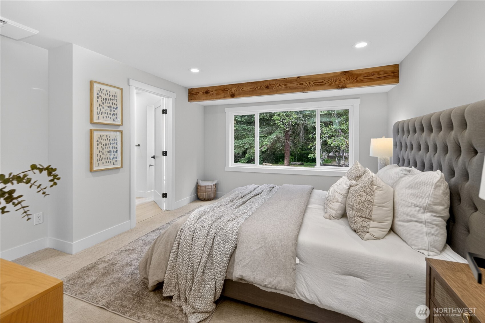 A large south-facing window looks out toward the back yard and surrounding trees, bringing in natural light by day and a soft evening glow as the sun begins to set. With room for a king-size bed, large sets of drawers, and a spacious walk-in closet, the primary bedroom offers the comfort, storage, and easy livability a true retreat should have.