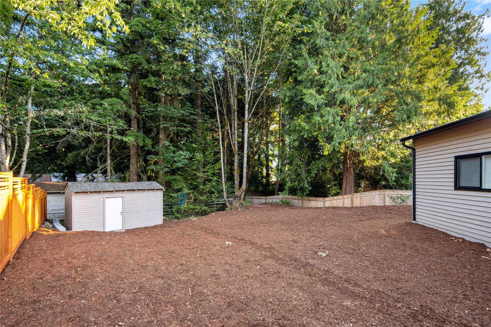 The detached garage includes its own fully fenced yard, creating a flexible outdoor area for projects, hobbies, pets, or extra workspace. A small shed keeps garden tools, lawn equipment, and seasonal items neatly tucked away, leaving the open yard ready for whatever life needs next, from planting projects to workshop overflow or simply a private outdoor space beside the garage.