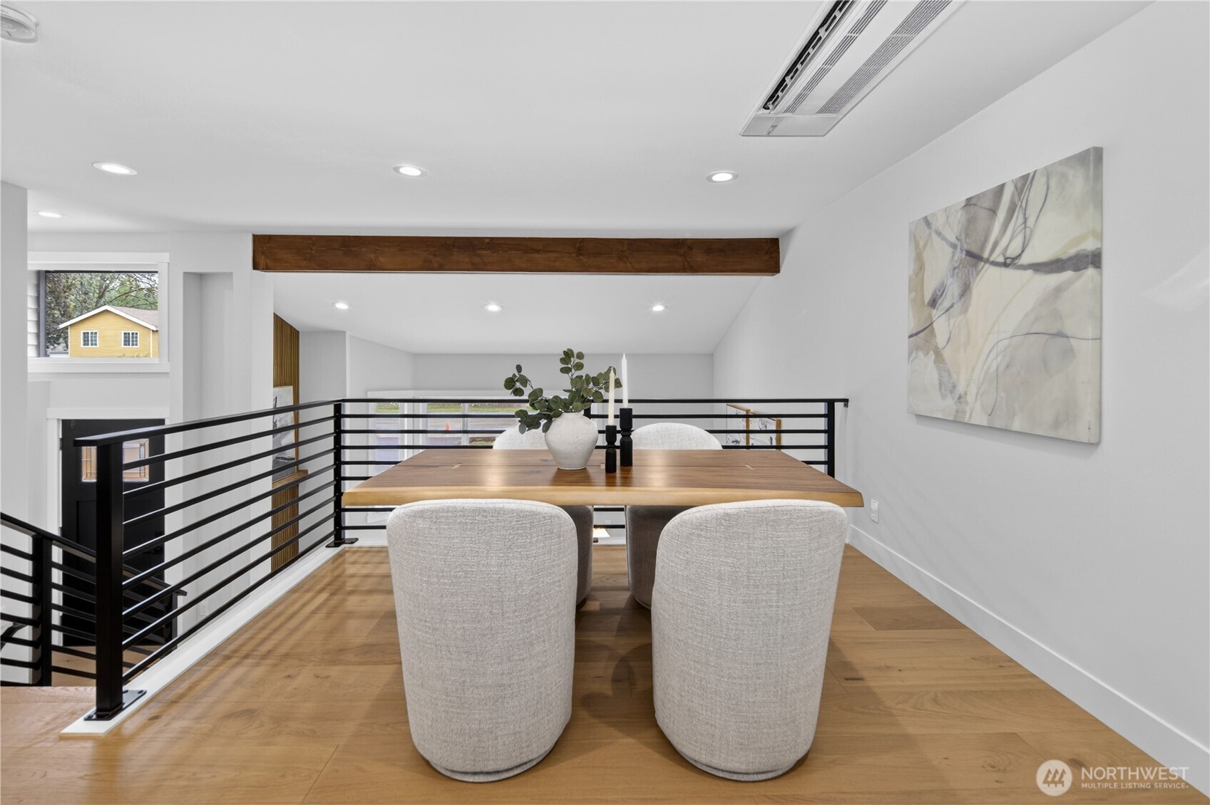 Set just above the front living room, the dining area enjoys a special sense of openness and connection. The custom linear handrail design accentuates the space, adding a clean modern architectural detail without closing off the view. Treetop views to both the front and back yards bring in natural light and a lovely outlook, creating a bright, inviting place to gather for meals and conversation.