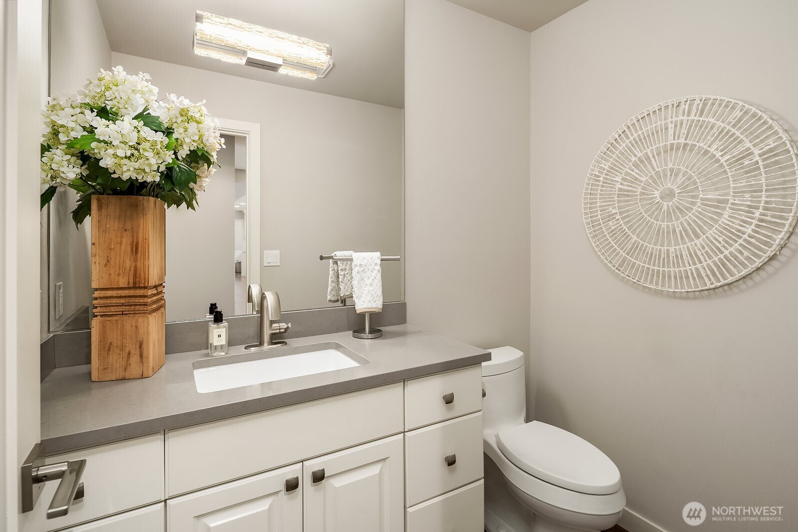 A tastefully updated powder bath features a classic white vanity and refined finishes, reflecting the attention to detail found throughout this extensively remodeled home.