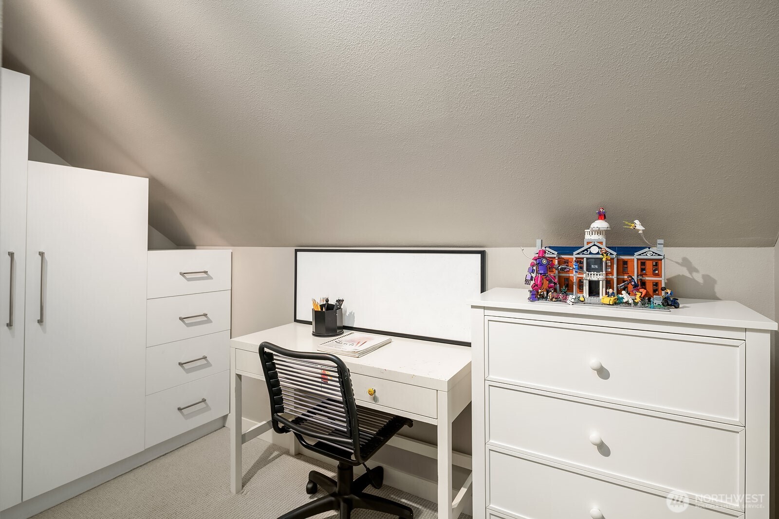 This versatile upstairs bedroom features built-in cabinetry and a dedicated desk area, making it an ideal space for a home office, study room, or flexible guest room.