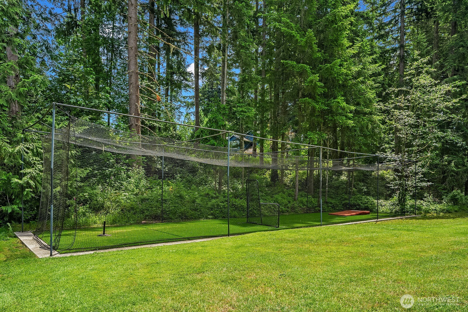 The professional 70-foot batting cage is perfectly situated along the tree line, making this property a rare find for baseball and softball enthusiasts with room to practice right in the backyard.