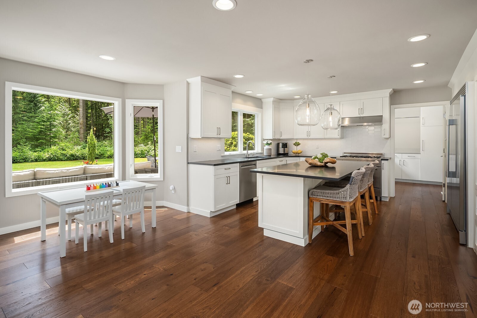The updated kitchen features a large center island, enhanced cabinetry, and designer finishes, with the breakfast nook and garden views just steps away for a bright and functional everyday living space.