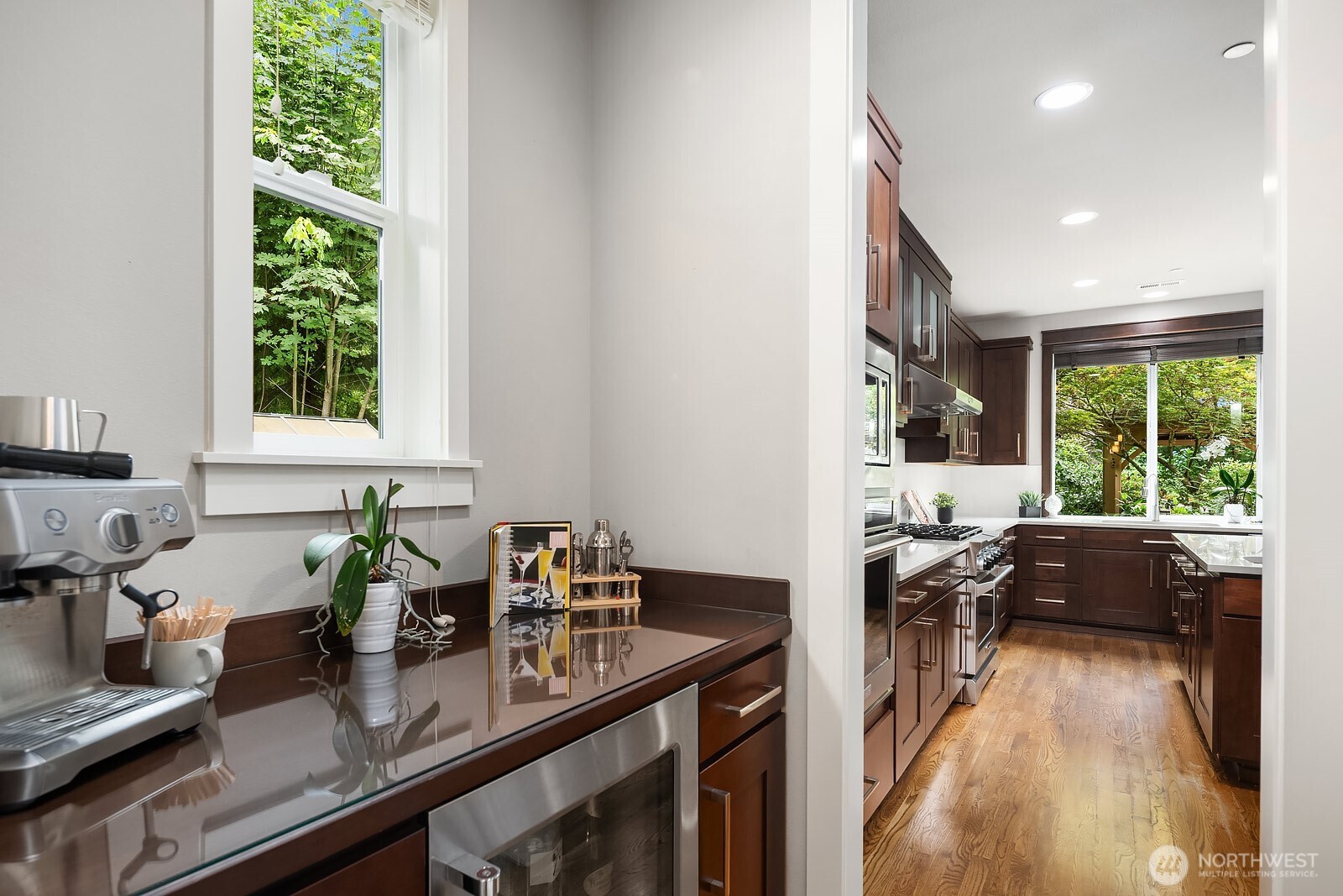 The well-appointed butler's pantry offers additional prep space and storage, thoughtfully connecting the chef's kitchen to the formal dining room for effortless entertaining. A beverage fridge and walk-in pantry complete this hardworking space that keeps the main kitchen clean and organized.