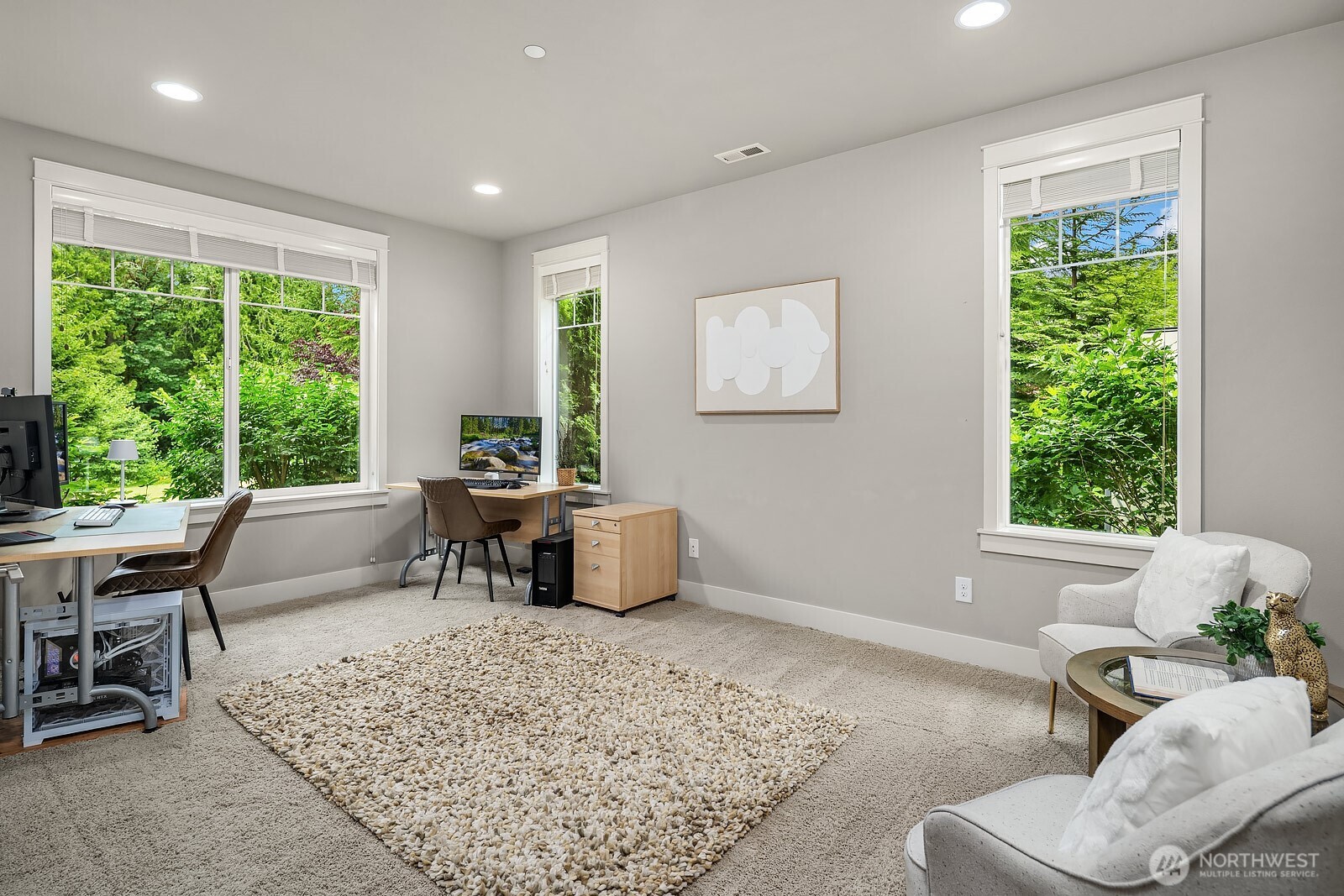 The dedicated main level office is bathed in natural light from multiple windows, offering a bright and private workspace with tranquil views of the surrounding greenery. Versatile and well-appointed, this flexible space could easily serve as a den or sitting room to suit any lifestyle.