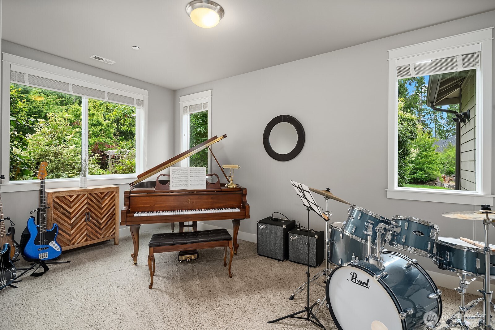 This flexible main level room offers endless possibilities, currently used as a music room and surrounded by windows that fill the space with natural light and garden views. Whether used as a den, playroom, or hobby space, this versatile room adapts beautifully to any need.