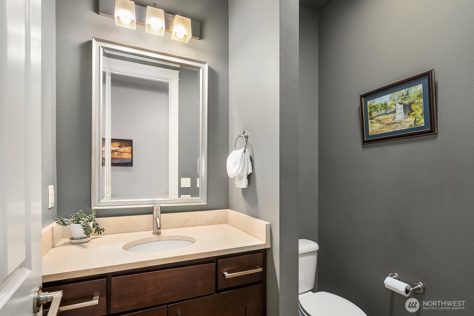 A stylish powder room features a well-appointed vanity and modern fixtures, offering a polished and convenient space for guests on the main level.