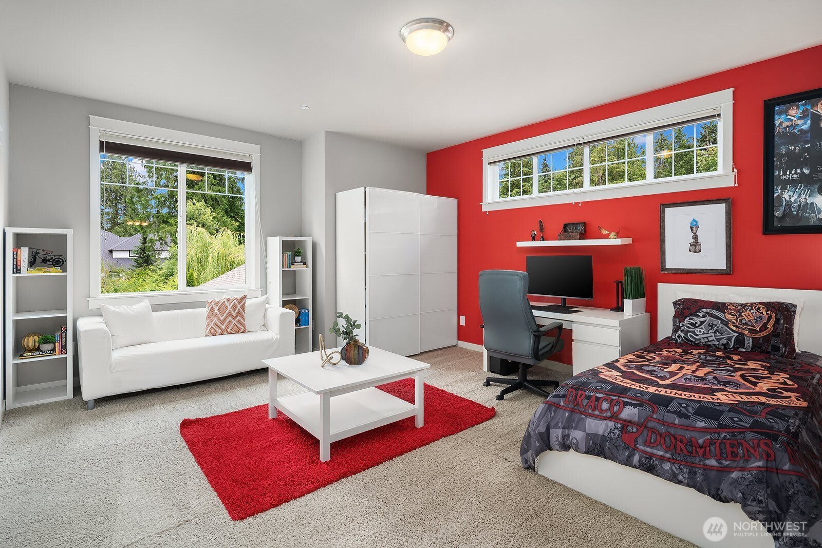 A spacious upper level secondary bedroom offers generous proportions, plush carpet, and a bright window wall with lovely outdoor views. The bold accent wall and flexible layout make this a fun and functional space adaptable to any style or need.