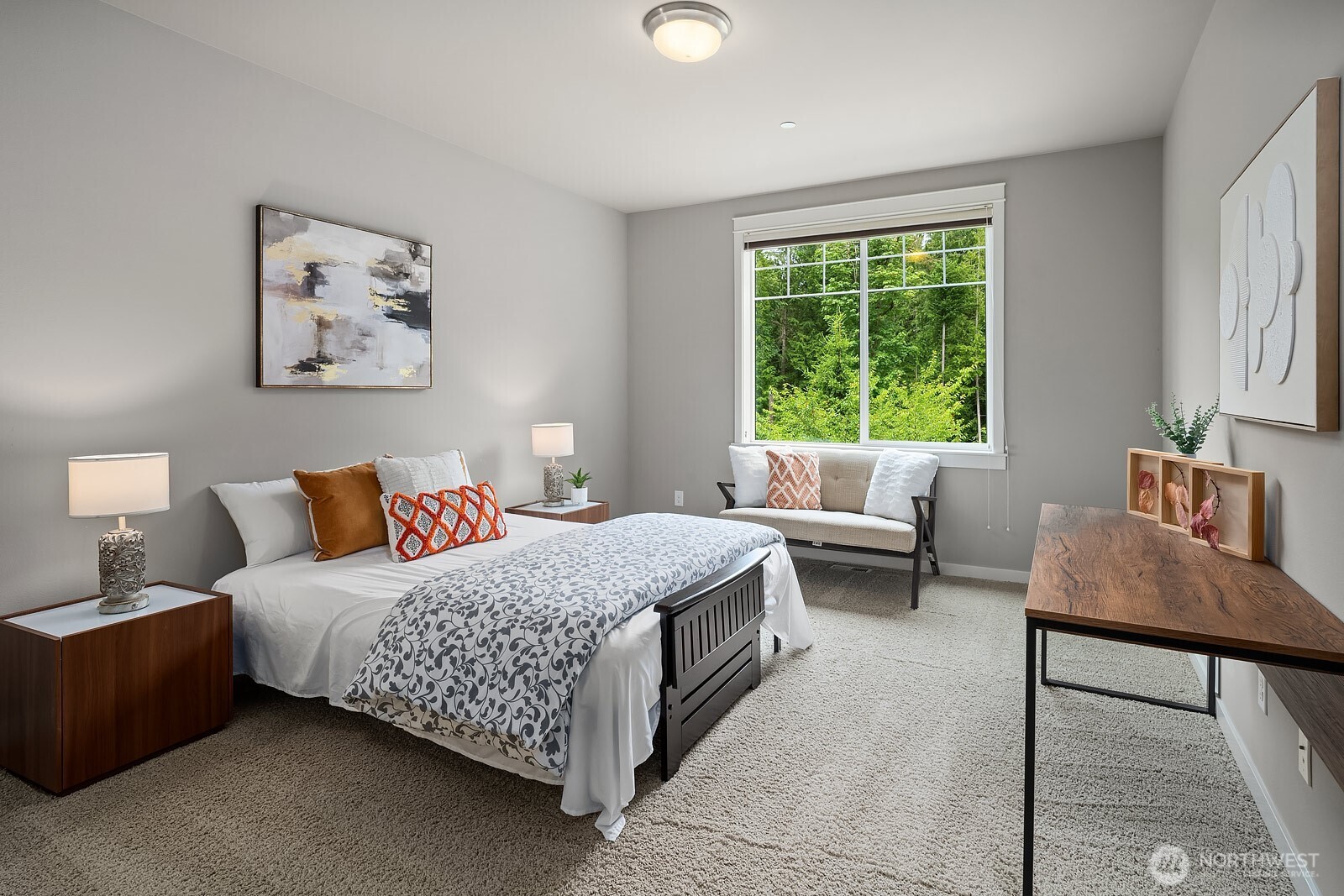 A bright and welcoming upper level bedroom features plush carpet, tasteful finishes, and a large window with peaceful views of the surrounding greenery, offering a comfortable and restful retreat.