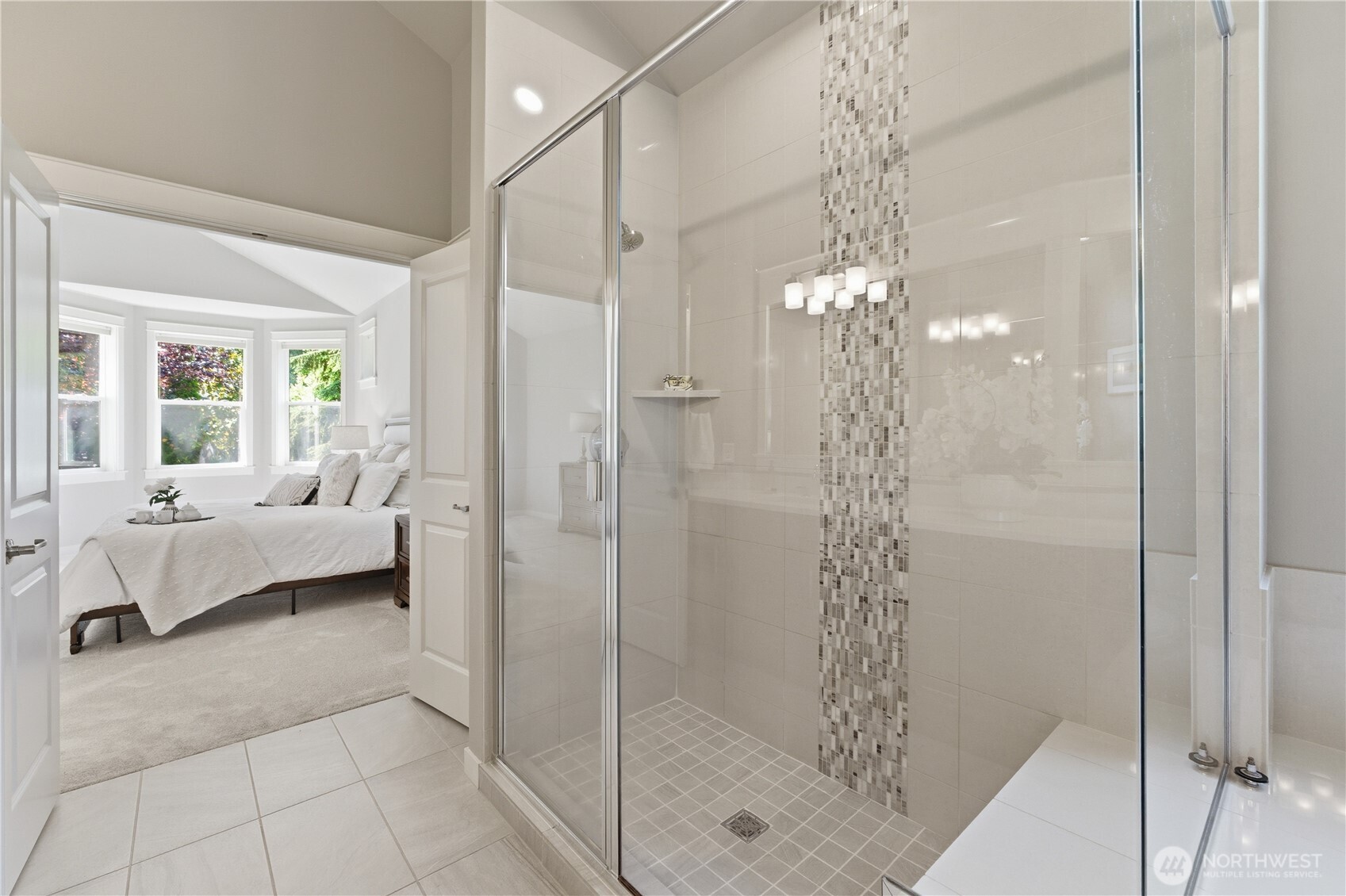 A beautiful walk-in shower featuring natural stone and detailed tile work