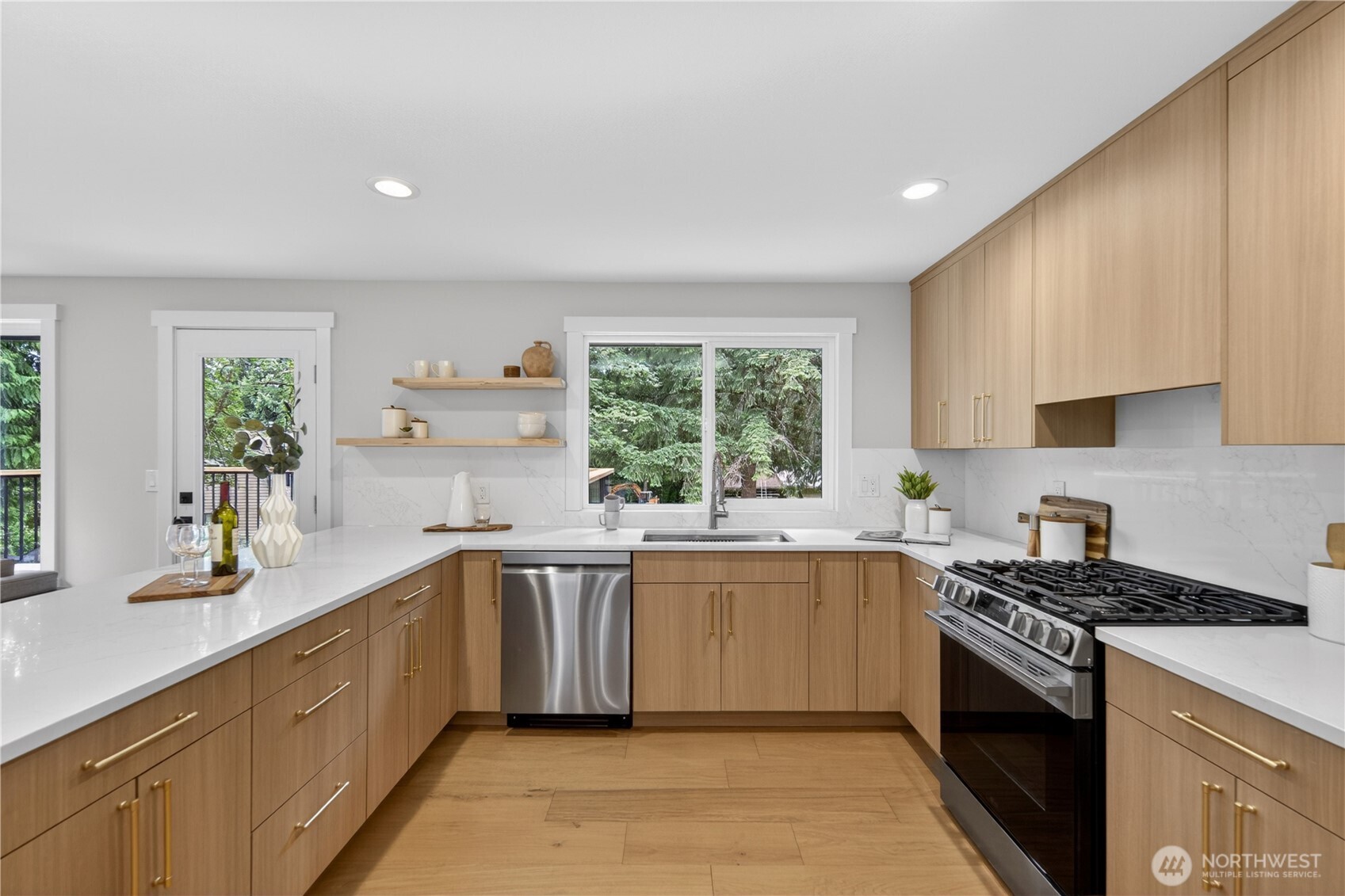 Even the daily task of doing dishes feels lifted here, with a large window over the sink bringing in green garden views and a sense of lightness to the routine. A graceful swan-neck faucet with easy sprayer, double sink, convenient dishwasher placement, and garbage disposal all help the work flow more smoothly. The dishwasher and all kitchen appliances are new LG, adding to the fresh, updated feel. Quartz counters and backsplash add beauty all around and make cleanup easier, turning an ordinary chore into something that feels far more pleasant.