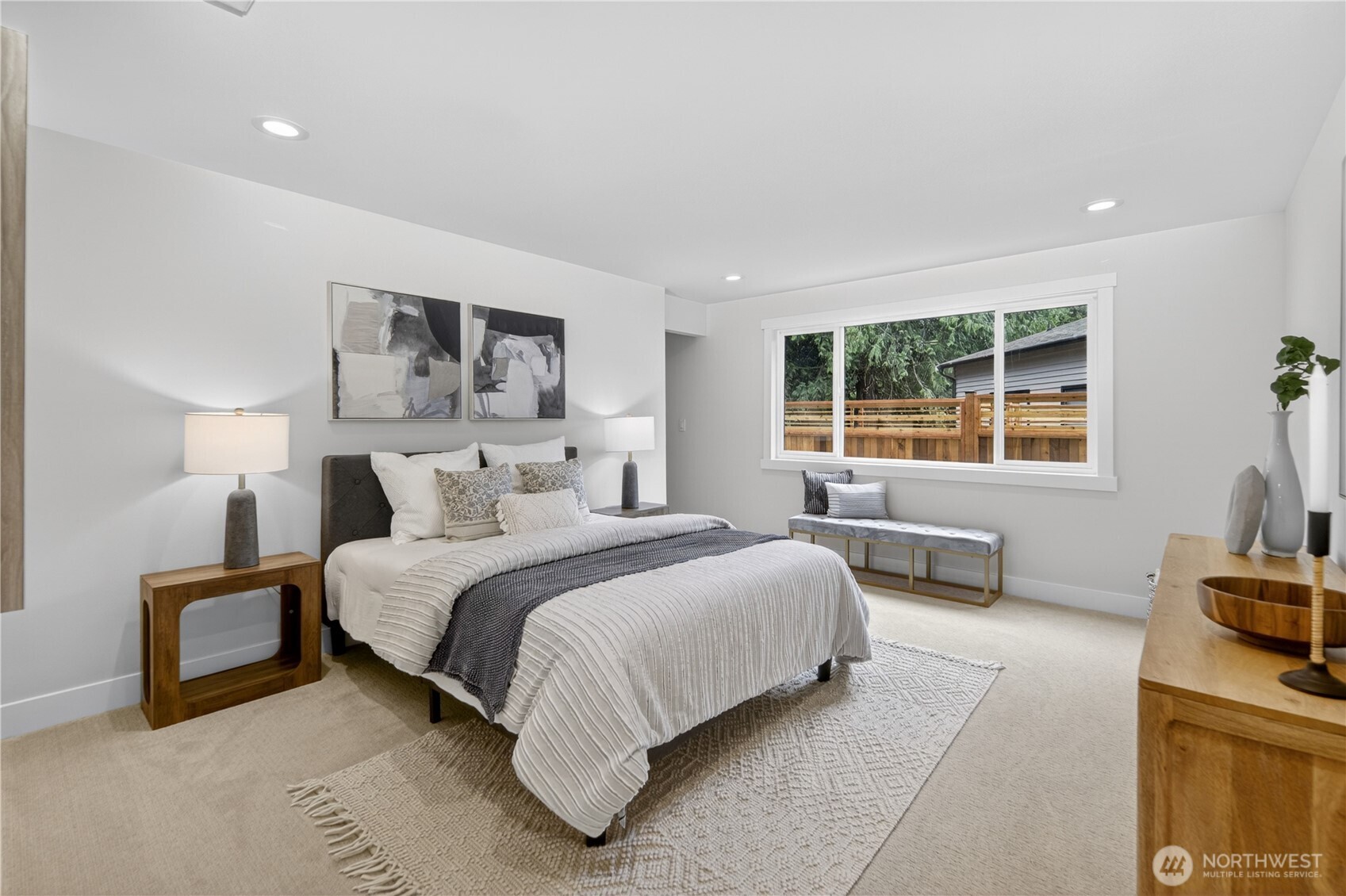 The downstairs bedroom feels bright and inviting, with large windows bringing in natural light, new carpet underfoot, and warm recessed lighting for an even glow. A generous closet offers plenty of room for clothing, making the room comfortable and practical for guests, extended family, or anyone enjoying the flexibility of the lower level.