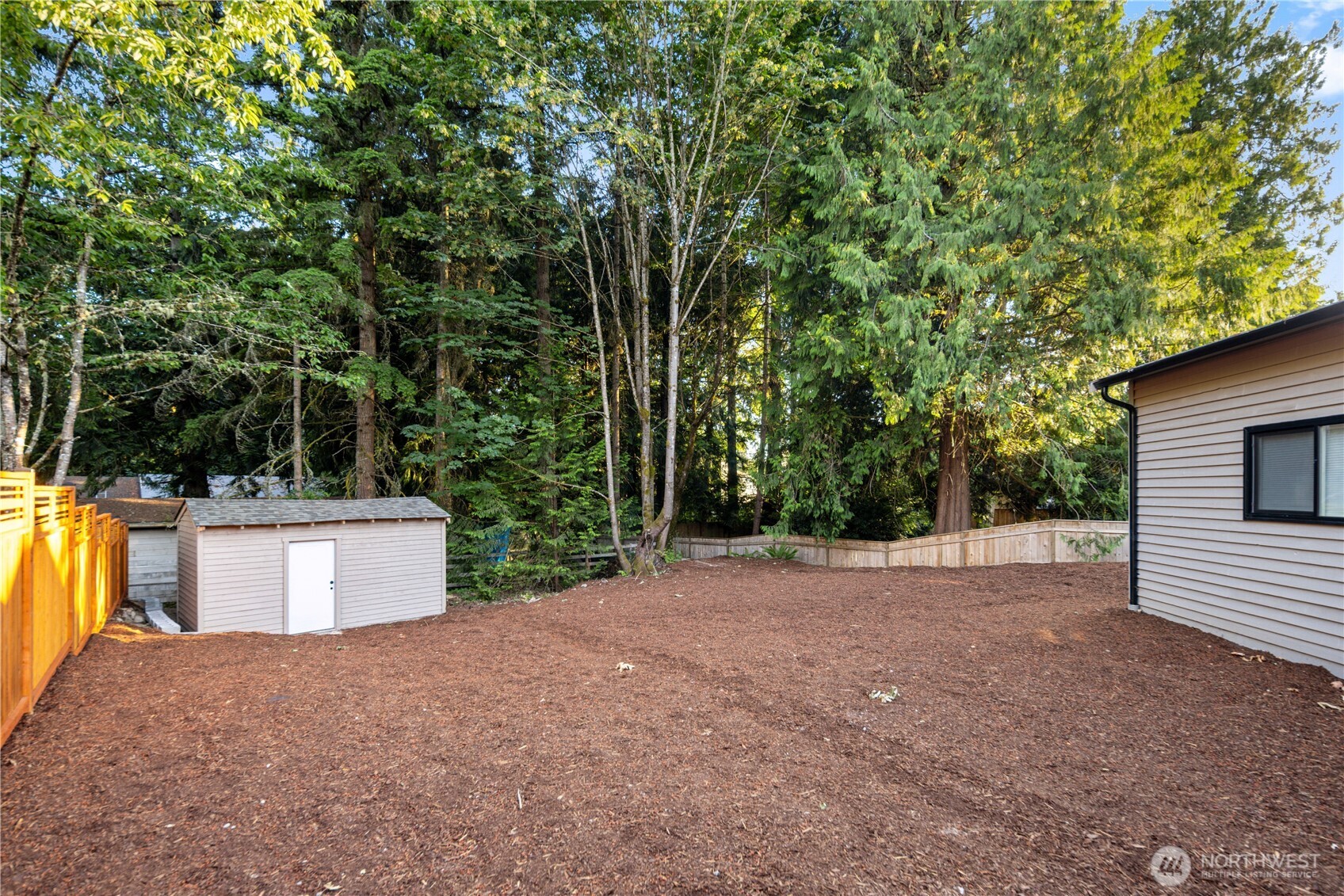 The detached garage includes its own fully fenced yard, creating a flexible outdoor area for projects, hobbies, pets, or extra workspace. A small shed keeps garden tools, lawn equipment, and seasonal items neatly tucked away, leaving the open yard ready for whatever life needs next, from planting projects to workshop overflow or simply a private outdoor space beside the garage.