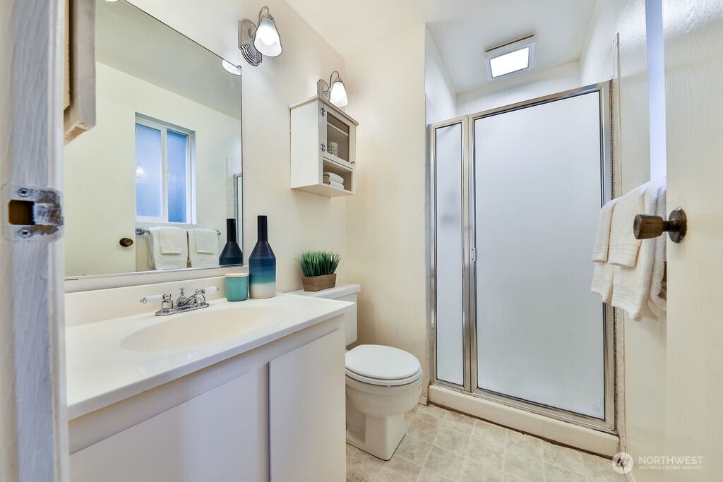 Large primary suite enjoys a view of the tranquil private backyard lined by mature statuesque trees and the convenience of a 3/4 bath ensuite.