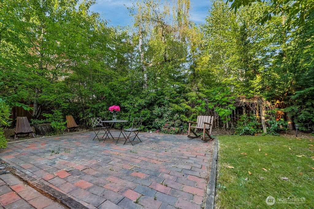 Surrounded by mature evergreen landscaping, cherry trees, and grape vines, the home's highlight is a beautiful, private backyard complete with a cedar deck, brick patio and line of statuesque trees providing total privacy.