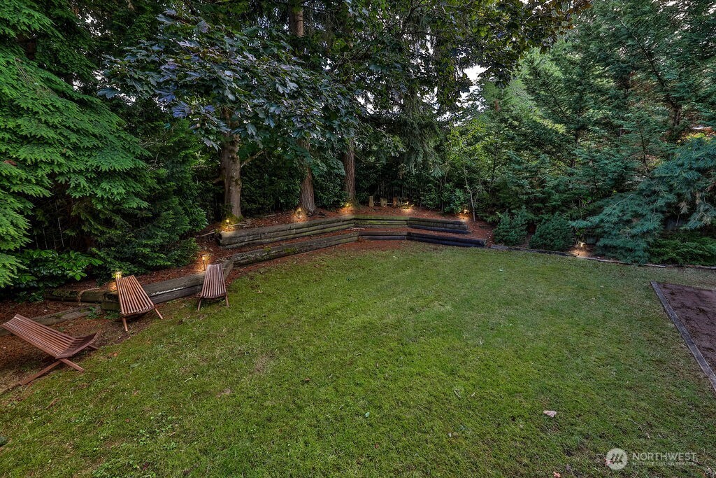 Surrounded by mature evergreen landscaping, cherry trees, and grape vines, the home's highlight is a beautiful, private backyard complete with a cedar deck, brick patio and line of statuesque trees providing total privacy.