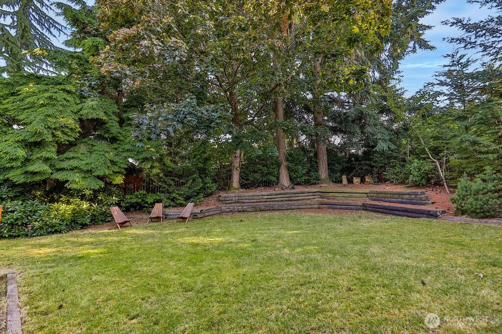 Surrounded by mature evergreen landscaping, cherry trees, and grape vines, the home's highlight is a beautiful, private backyard complete with a cedar deck, brick patio and line of statuesque trees providing total privacy.