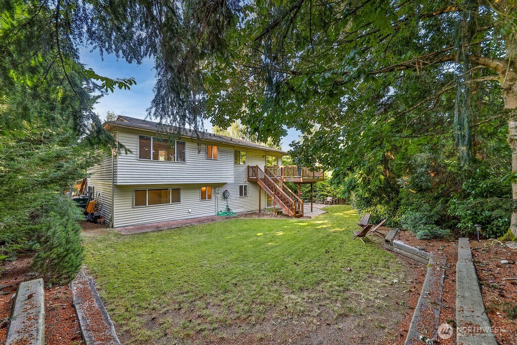 Surrounded by mature evergreen landscaping, cherry trees, and grape vines, the home's highlight is a beautiful, private backyard complete with a cedar deck, brick patio and line of statuesque trees providing total privacy.
