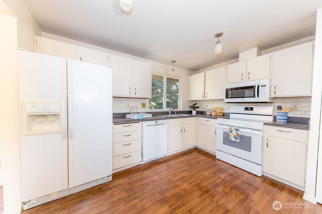 Beautiful Pergo floors and a layout that allows easy entertainment and dining to flow from the living room and kitchen into the dining room and outside onto the cedar deck.