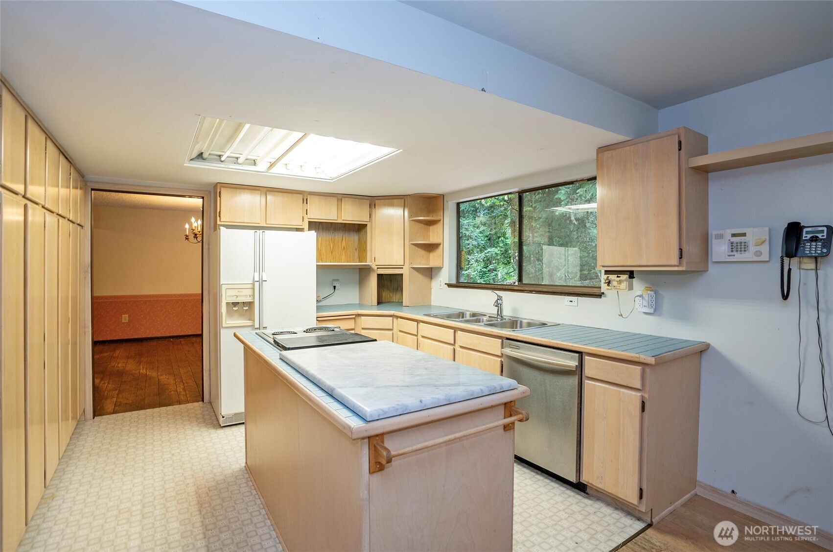 Spacious island kitchen with serene views of the secluded, private backyard.