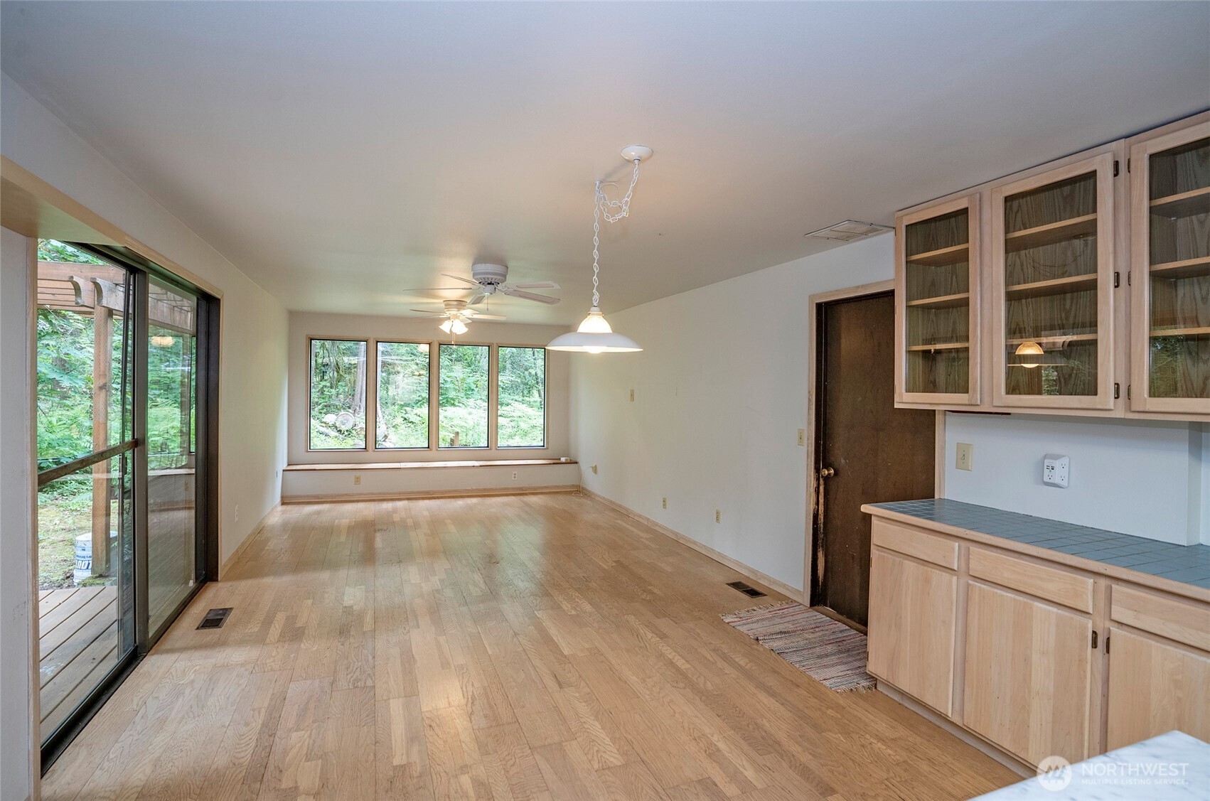 Family room features a built-in bench beneath expansive windows, adding charm, comfort, and functionality.