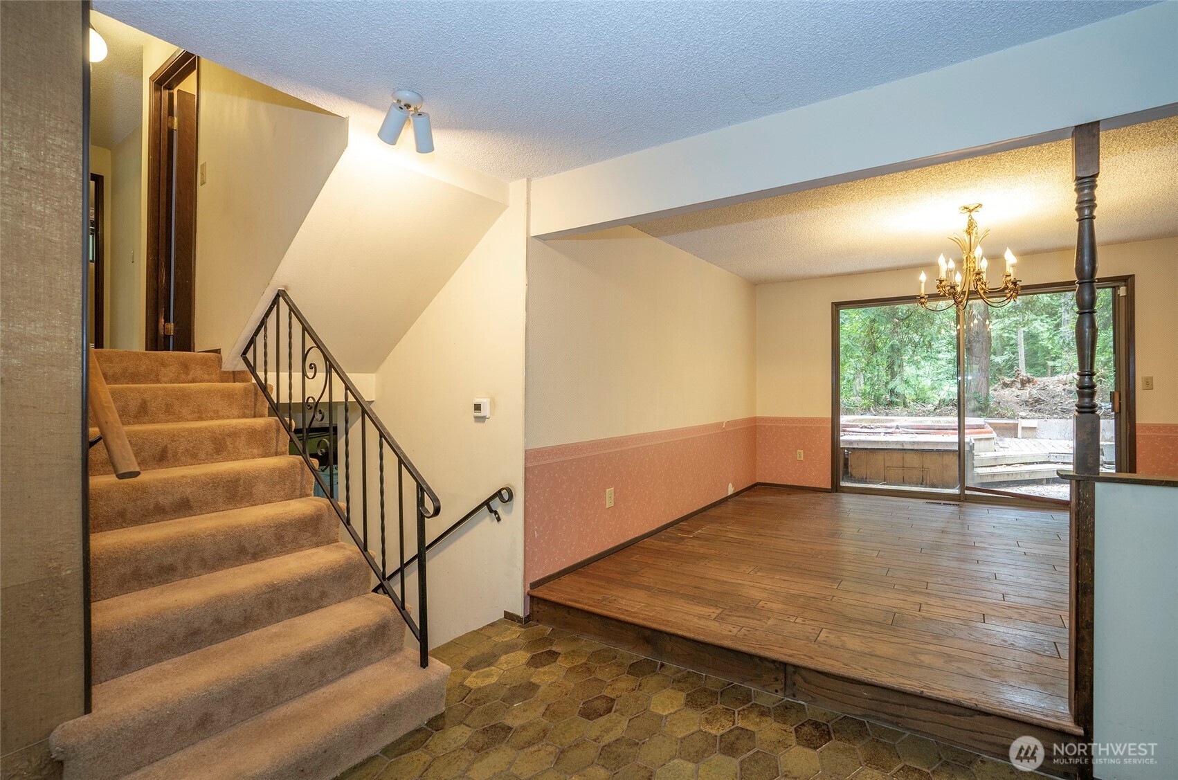 Dining area with stairs to the left leading to the upper level, which features the primary suite with ¾ bath, guest suite, and full guest bath.