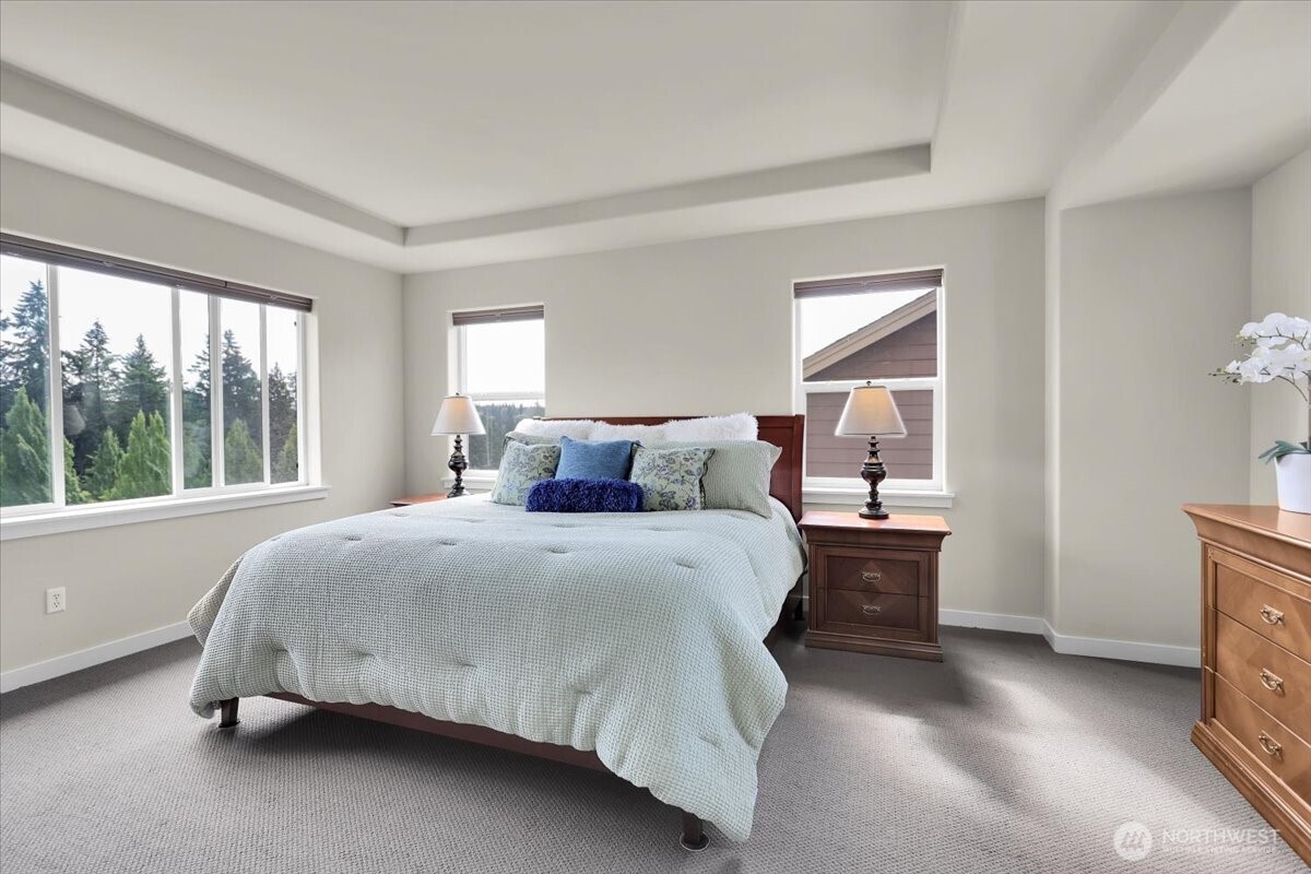 Primary Suite hosts a king size bed and has Windows on 3 walls