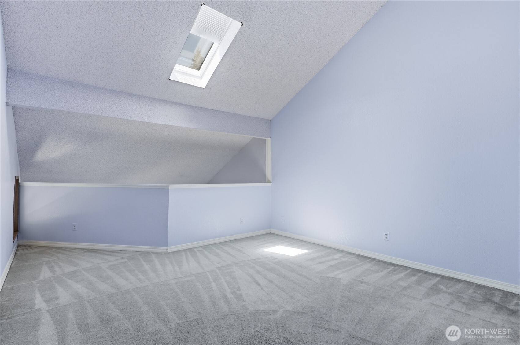 Large spacious primary bedroom with skylight that opens with shade.