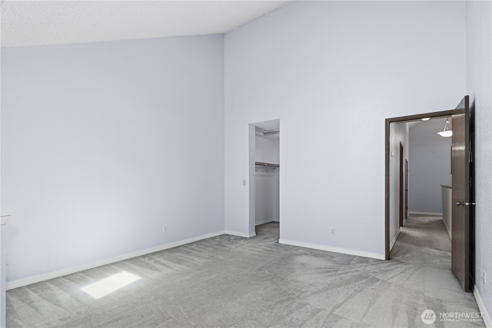 Primary bedroom with vaulted ceiling and access to closet area and also main upstairs hallway.