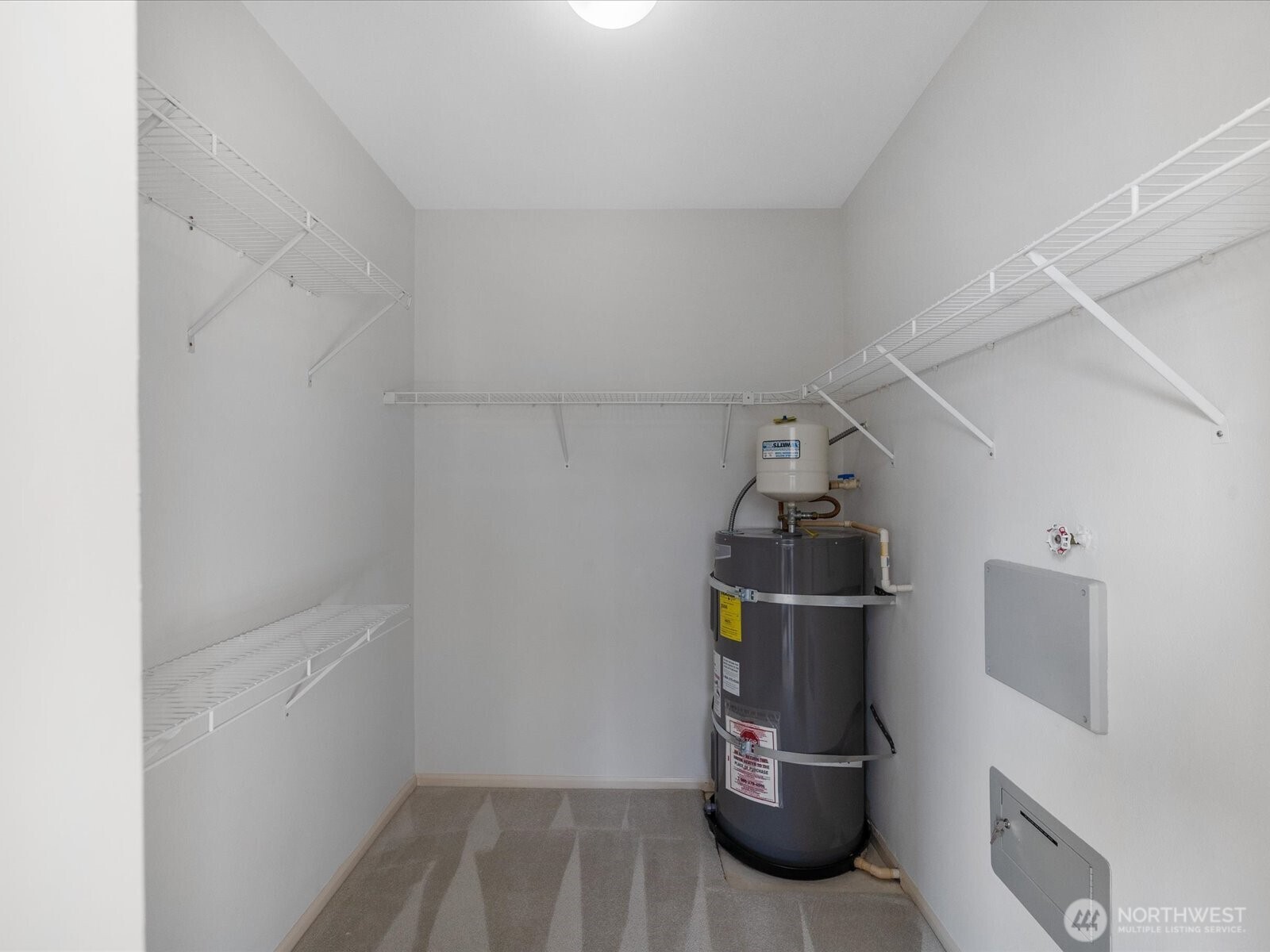 Walk in closet with built-in shelving with ample space, and easy access to the water supply.