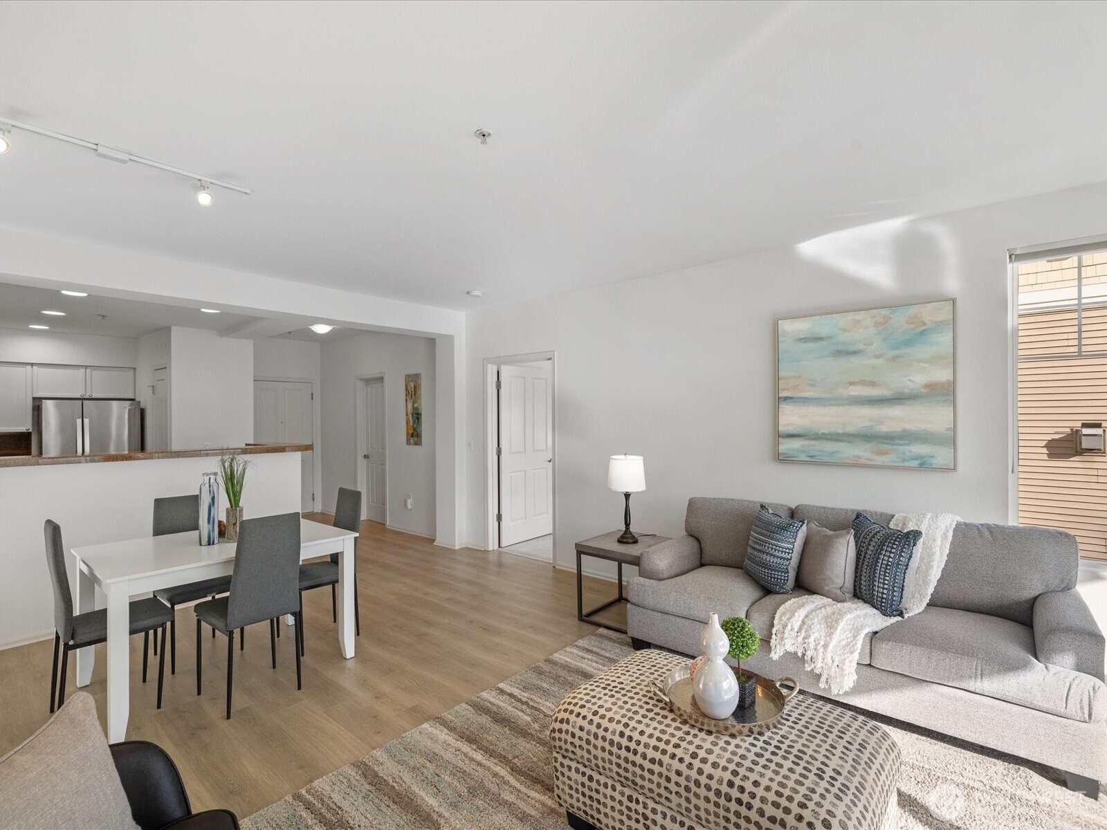 Living and dining area with open layout, connecting kitchen, seating area, and adjacent rooms for functional interior flow.