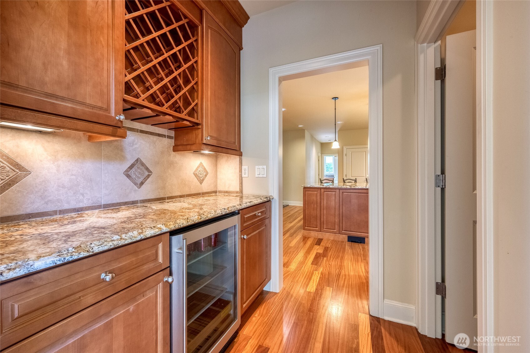 A sophisticated butler’s pantry with wine refrigerator and an oversized walk-in pantry adds both luxury and practicality, creating an ideal space for entertaining and organization.
