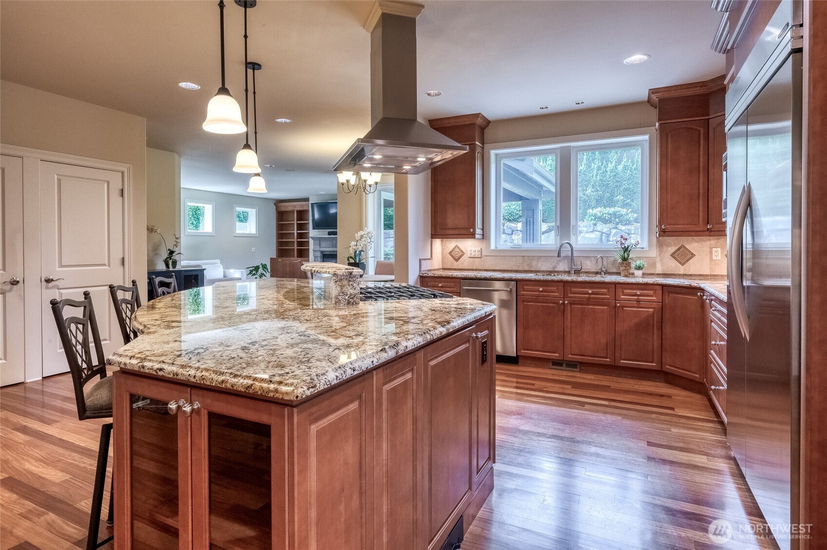 An expansive dining island and sophisticated granite slab countertops with refined bullnose detailing.