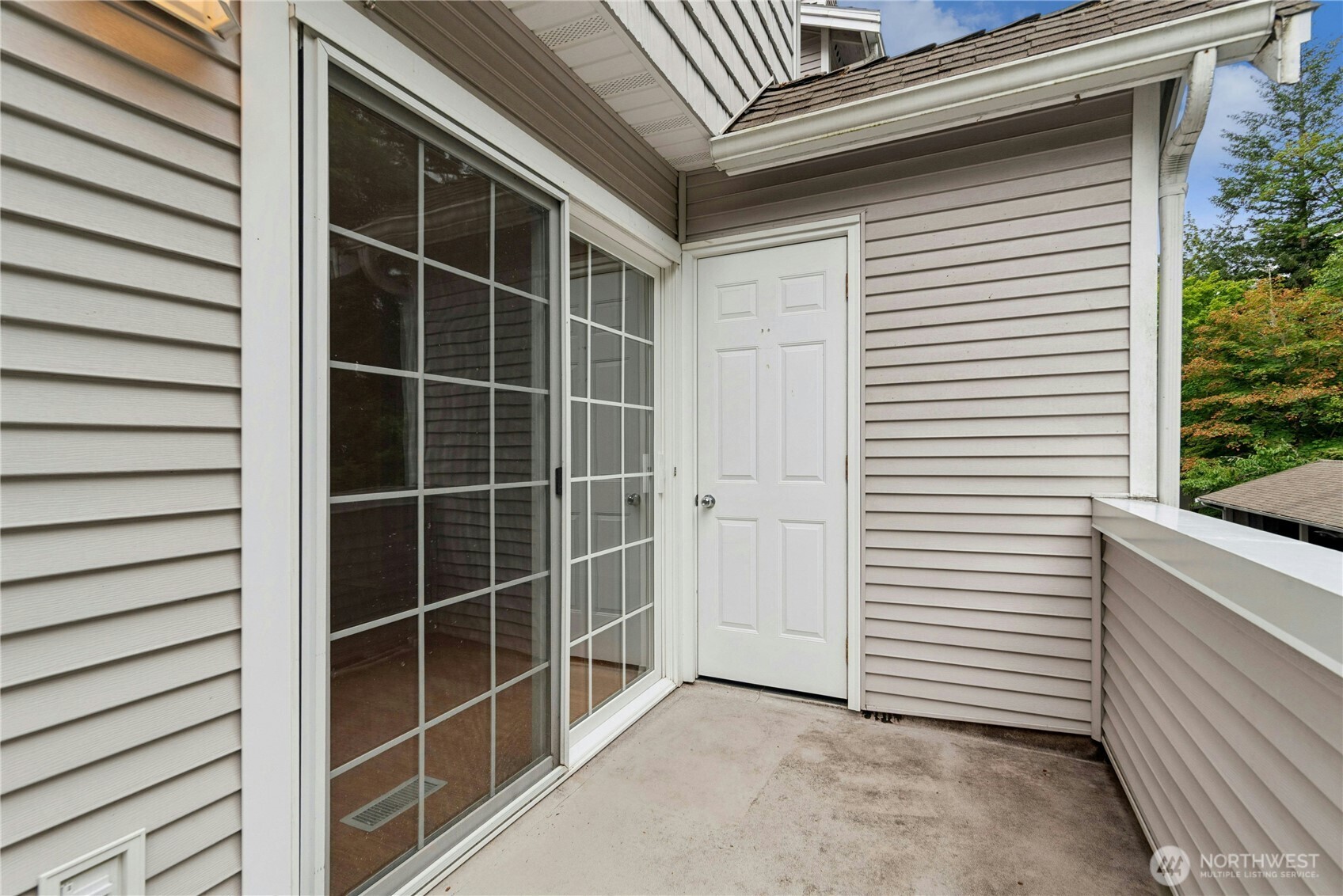 Rear deck overlooking a peaceful treed setting, perfect for relaxing or outdoor dining.