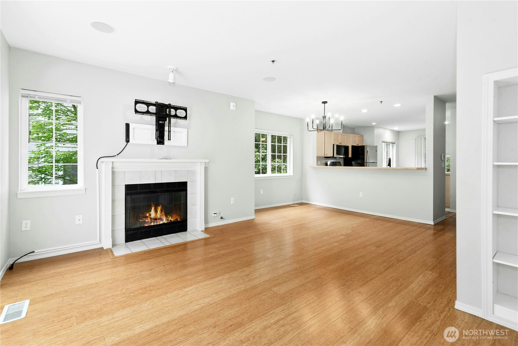 Open living room with vaulted ceilings, gas fireplace, and abundant natural light.