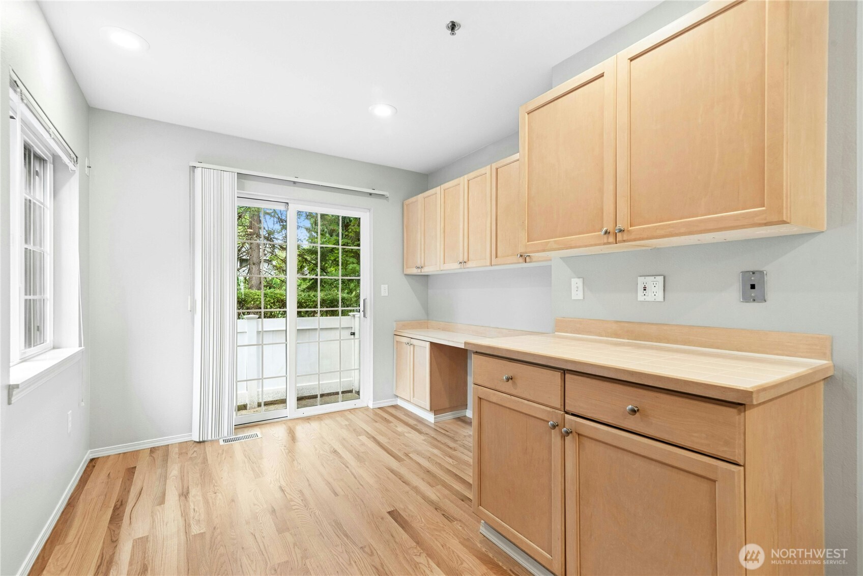 Alternate view of the bright breakfast nook with large windows overlooking the rear deck and treed setting.