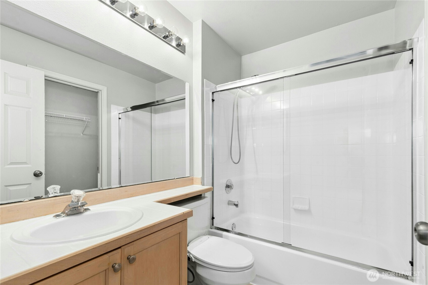 Primary ensuite bath with oversized vanity and tub/shower combination.