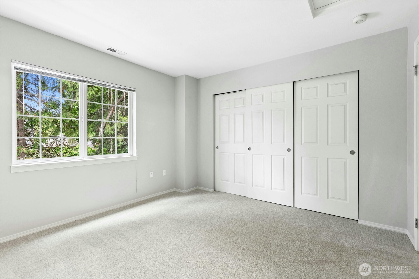 Alternate view of the second bedroom with large window and generous closet space.