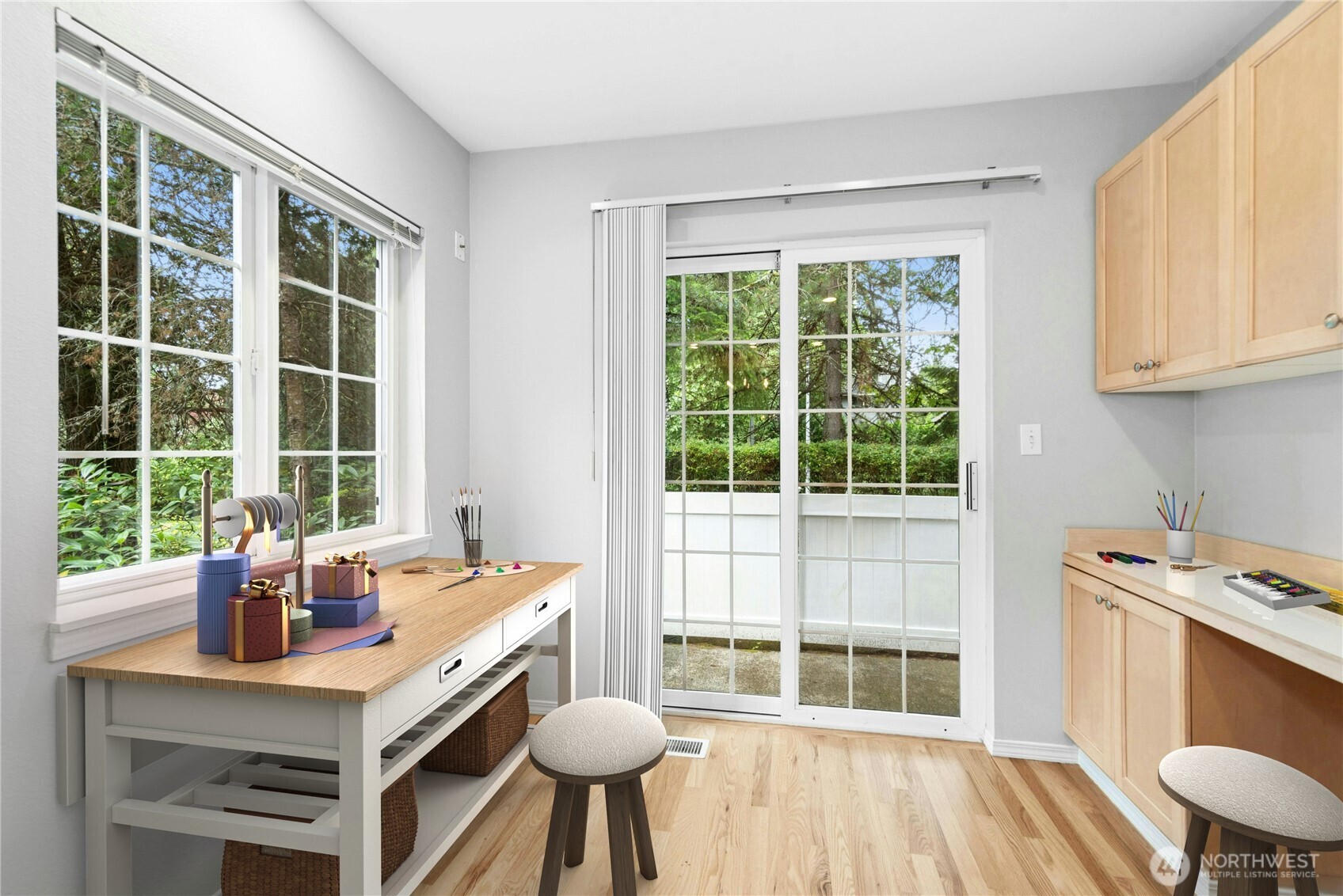 Virtually Staged - Bright breakfast nook shown as a crafting and hobby space with views of the rear deck and surrounding trees.