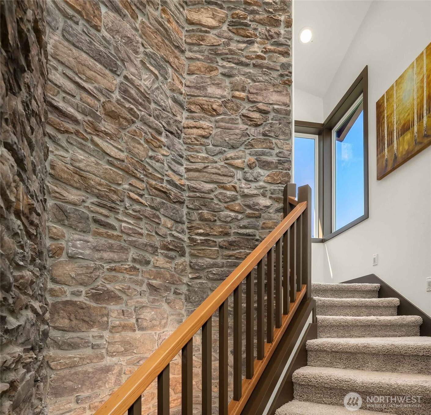 This stunning rock wall encompasses all three floors and includes gallery lighting.