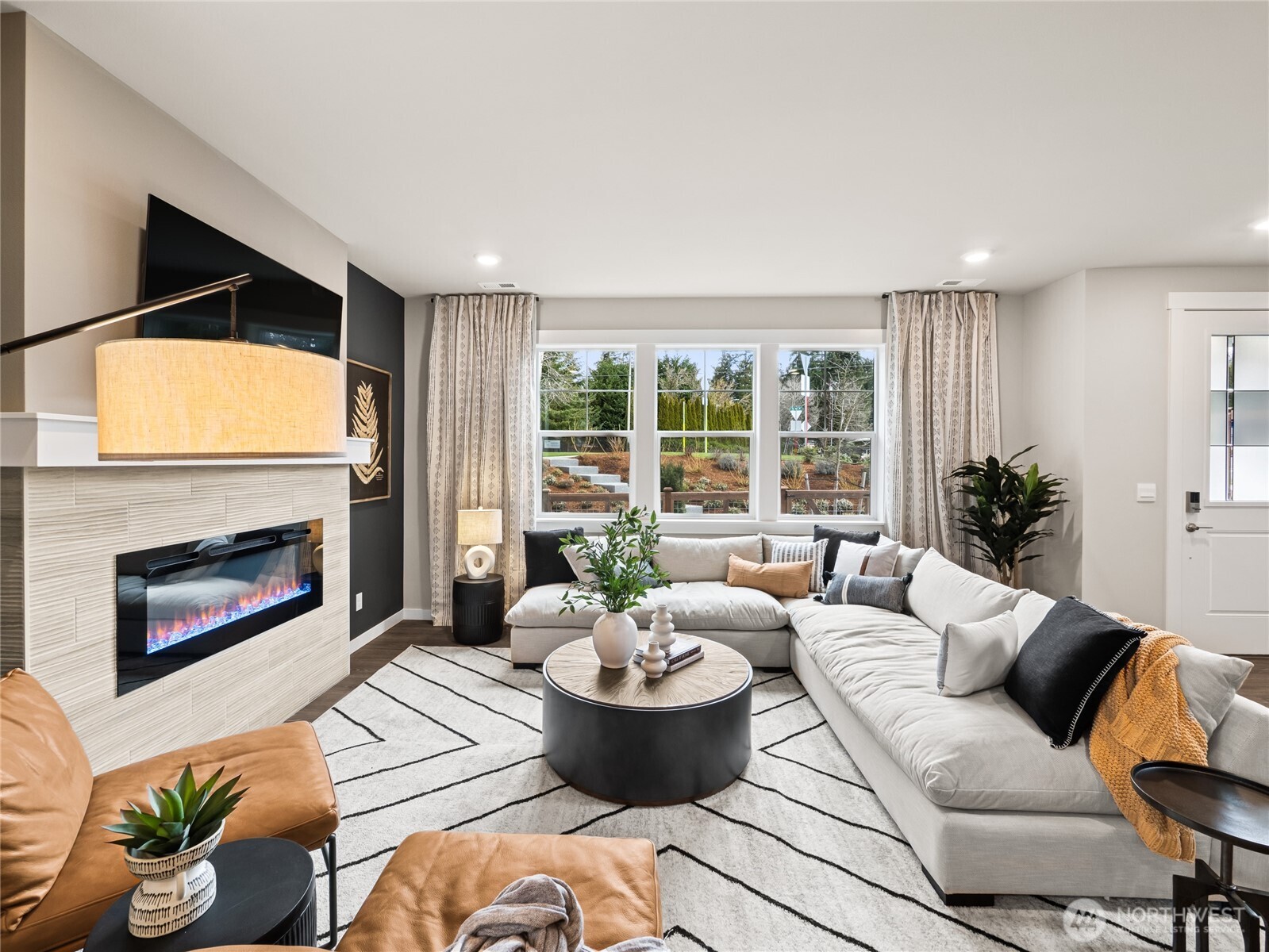 Large family room view with cozy fireplace with loads of windows. Photo is representational. Actual home is under construction and finishes and paint colors may vary. See site agent for details....