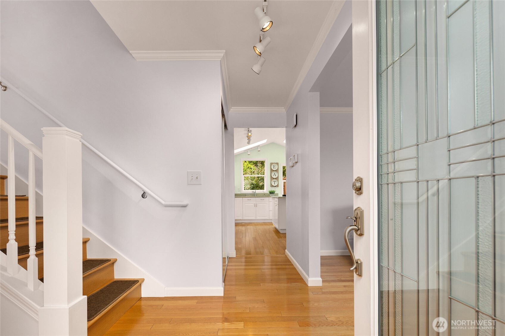 An inviting entryway with hardwood floors and bright spaces greets you.