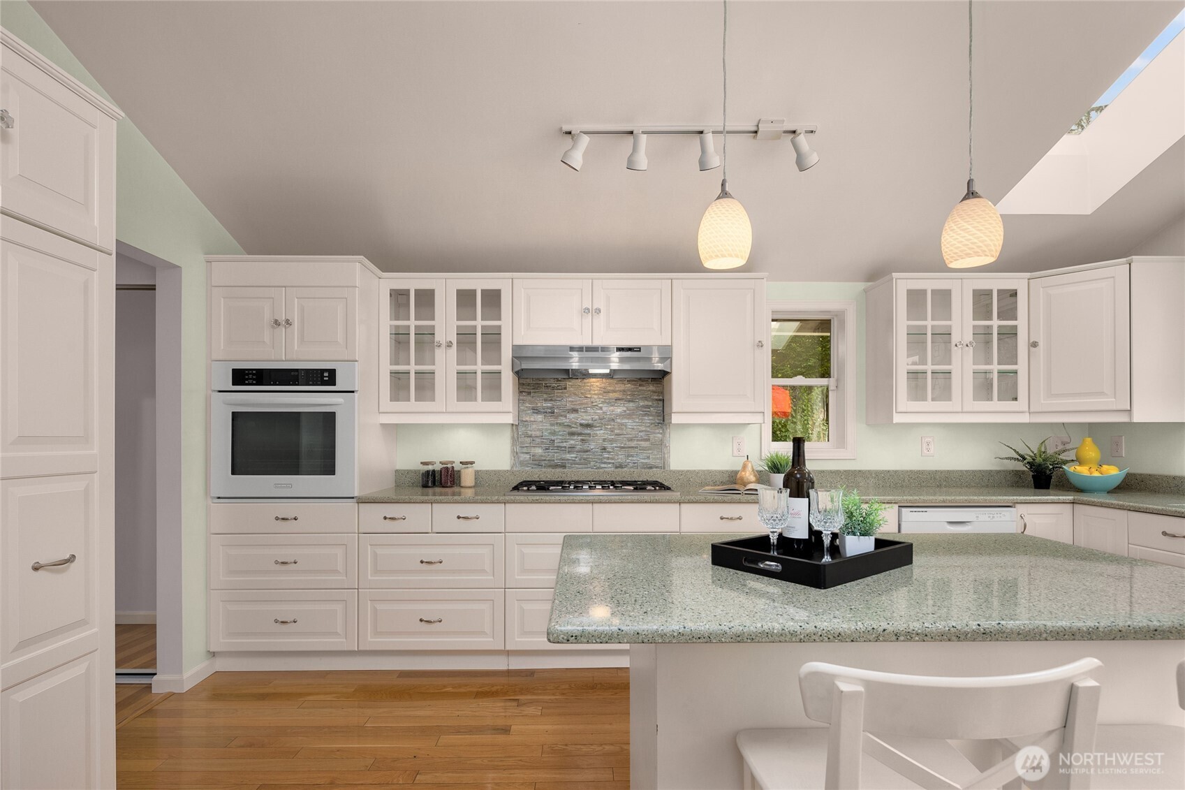 This remodeled kitchen has ample cabinet storage and meal prep areas on the durable quartz countertops.