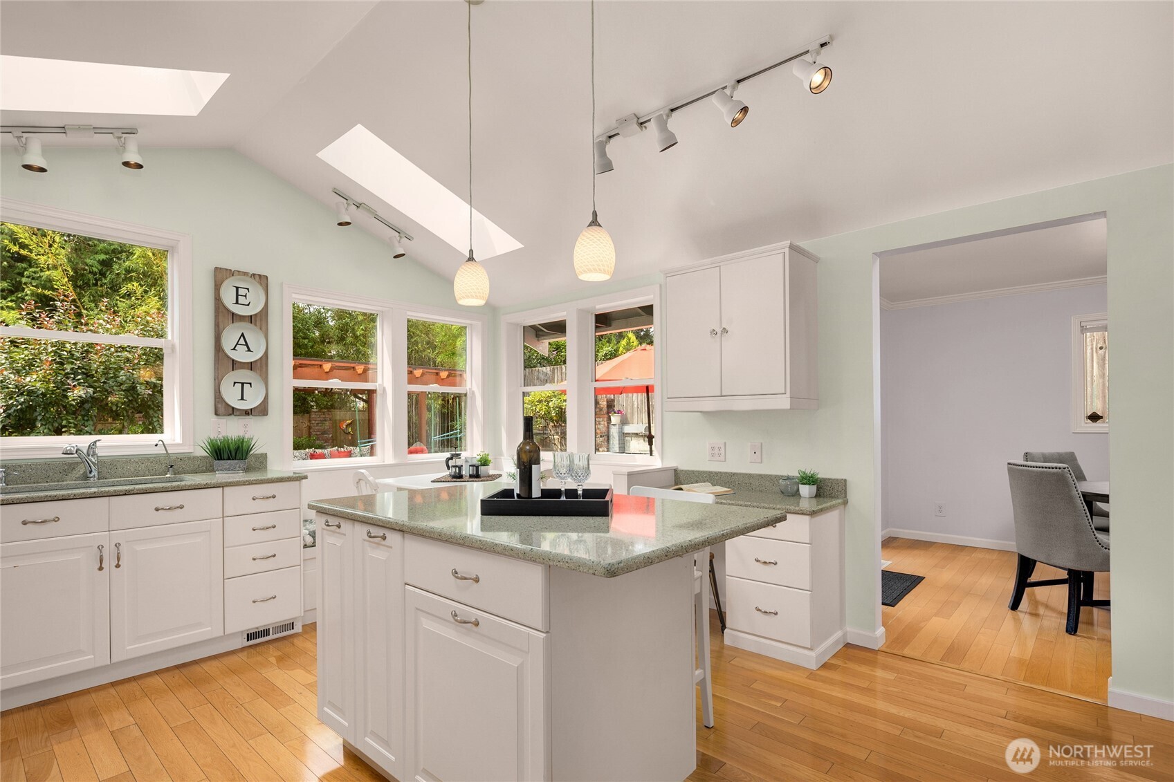 The kitchen has perfect a flow and stylish finishes. Notice the numerous windows surrounding the eating nook!