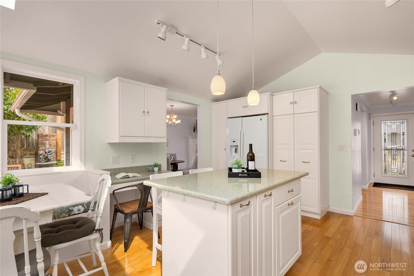 Another kitchen view showing the entry, built-in kitchen desk & built-in seating.