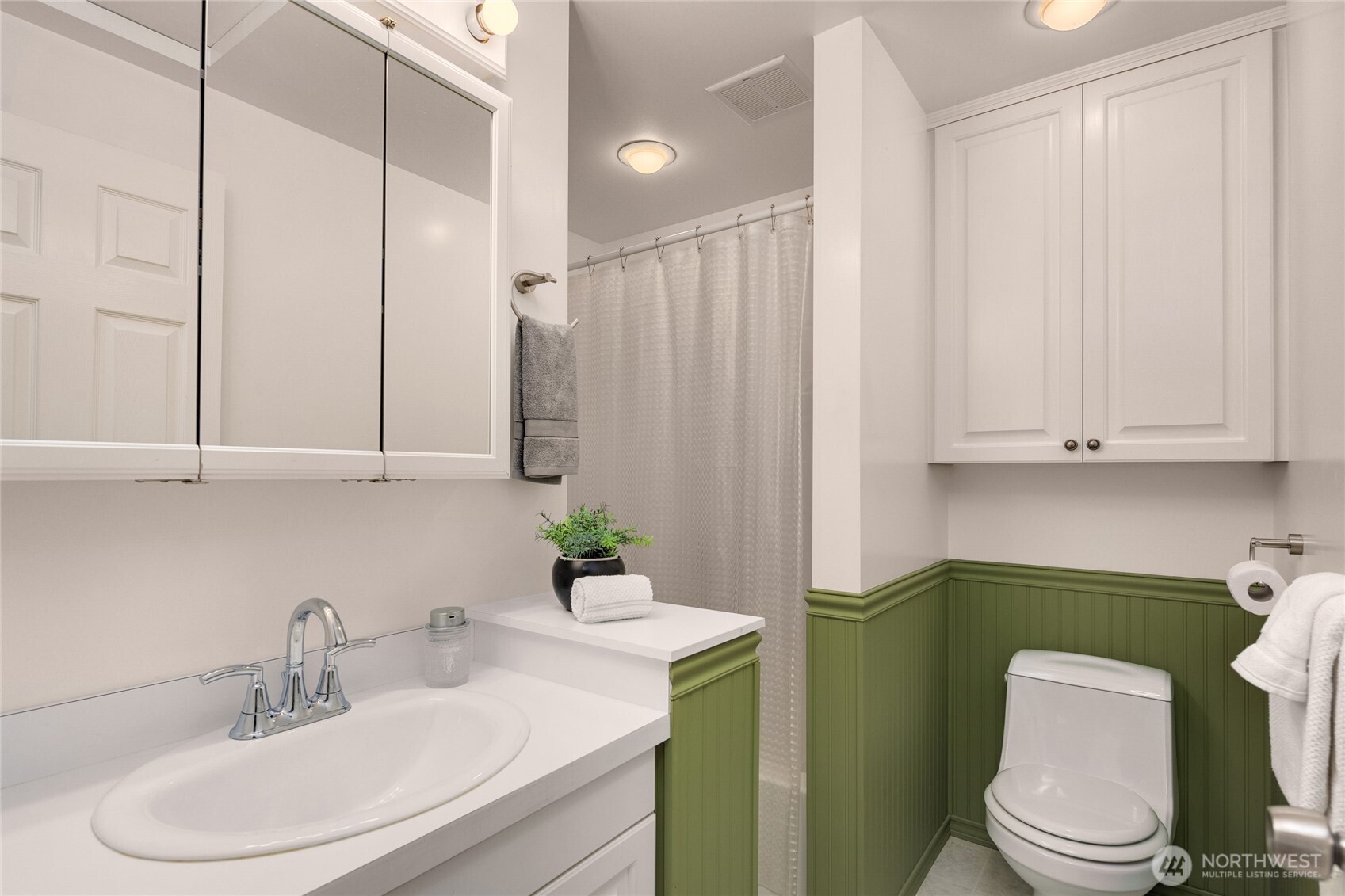 Upper, remodeled full bath off the hallway with wainscoting.