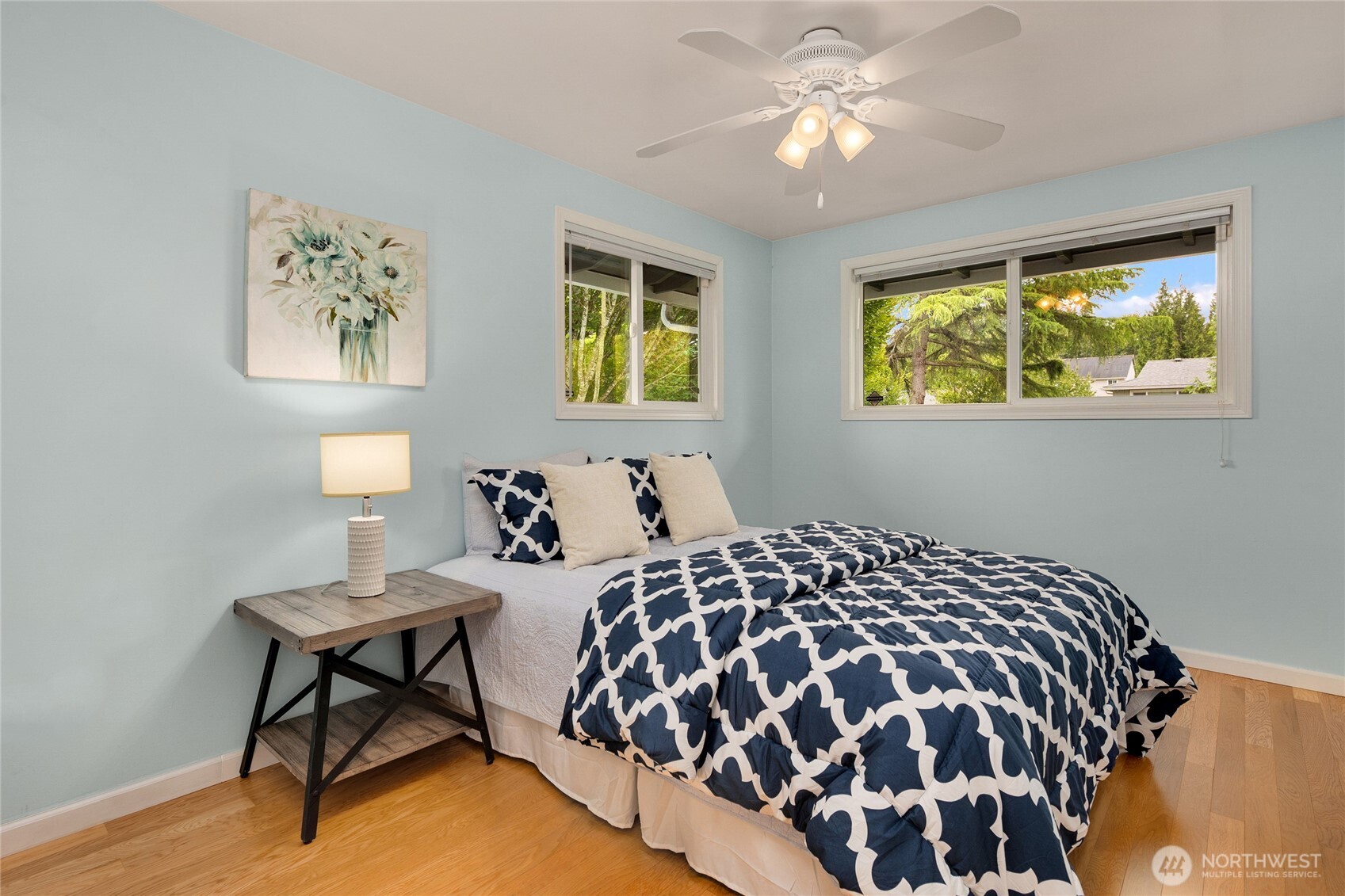 The second upper level bedroom with hardwood floors and a ceiling fan with views of the beautiful backyard.