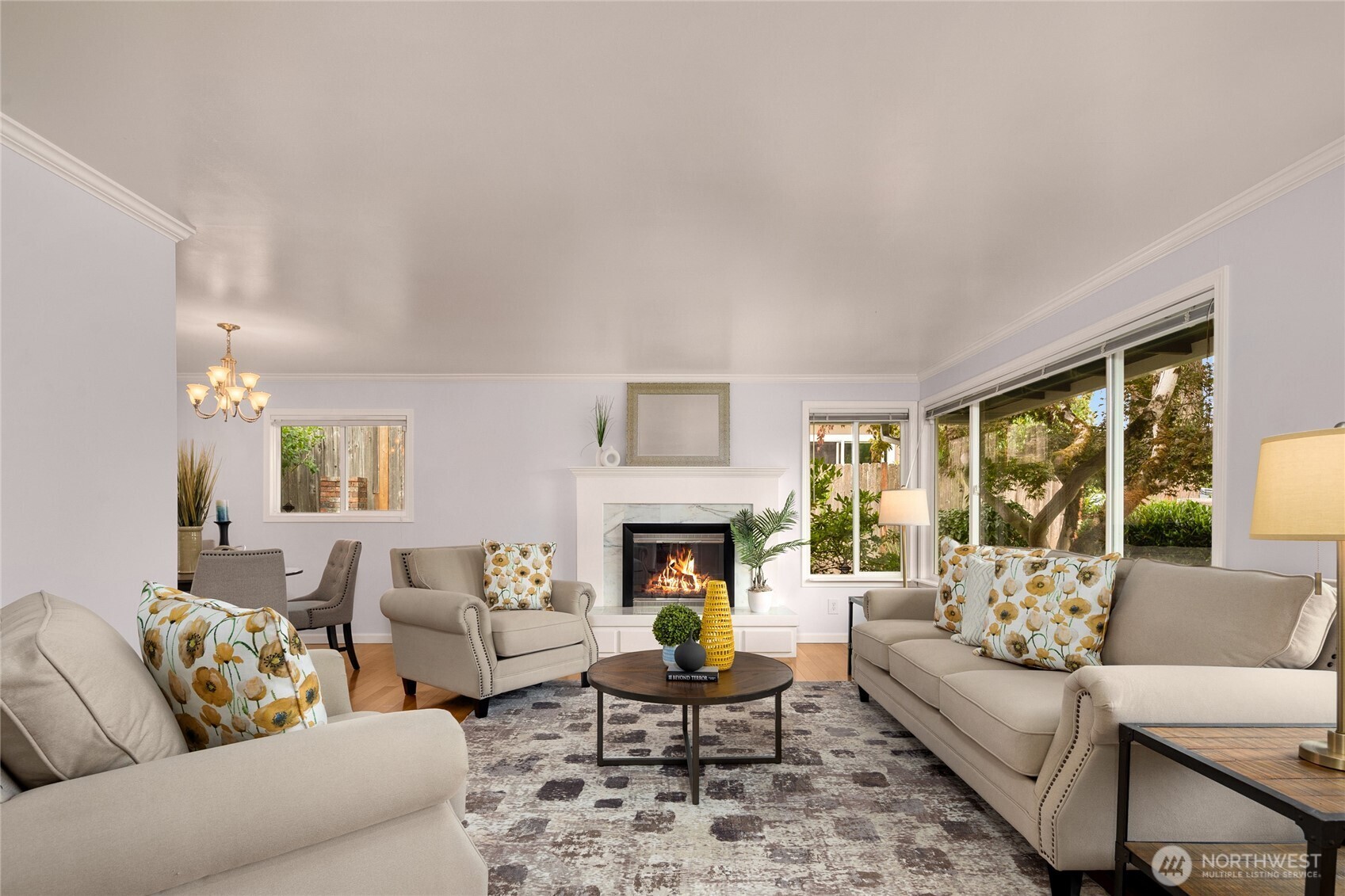 Enjoy a comfortable living room with hardwood floors and a wall of large windows that bring in the natural beauty of the landscaping.