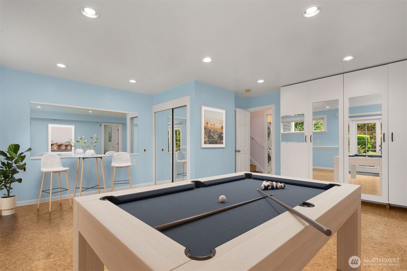 Virtually staged. The lower family room was used as a fitness room. It has durable cork flooring. This multipurpose room is large and has double doors to the backyard. Virtually staged as a game room.