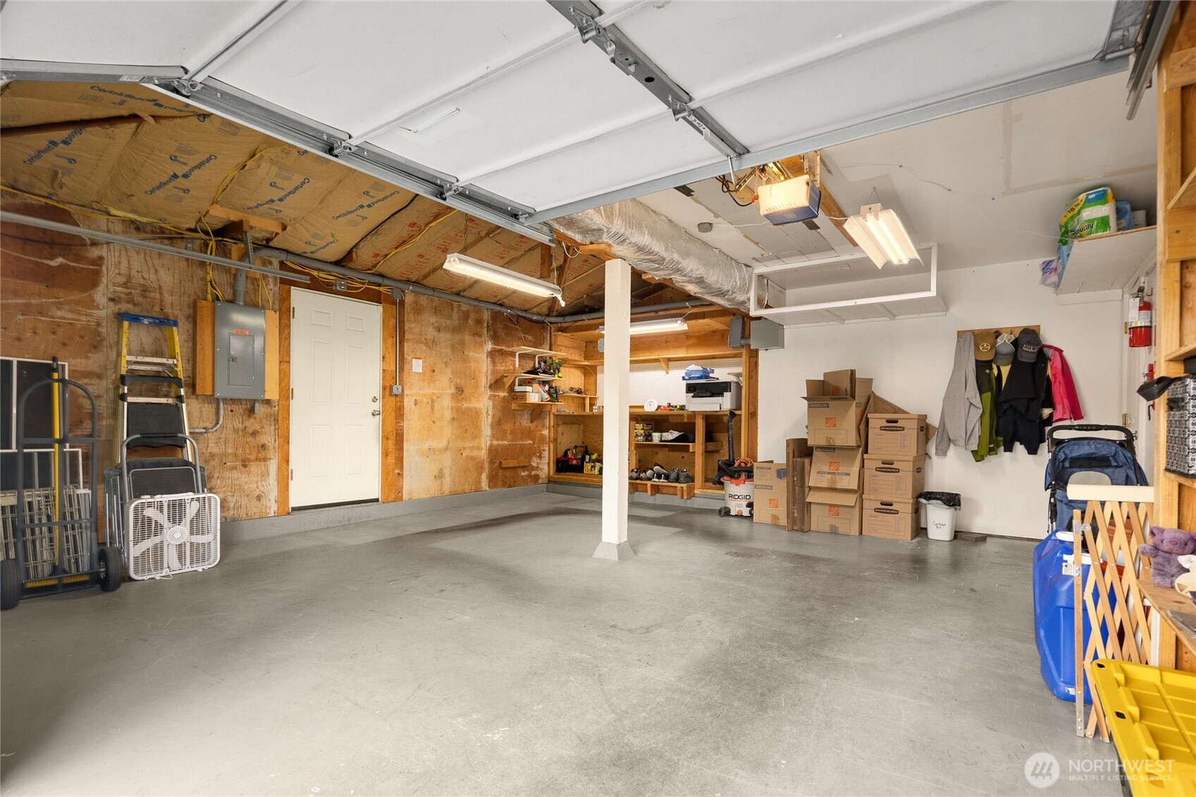Spacious 2 car garage with additional tool area & storage in the back.